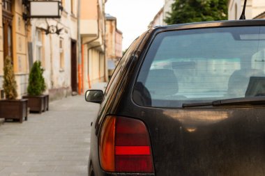 Yazın güneşli bir günde, arka pencereye park edilmiş siyah bir araba. Çıkartma veya çıkartma için modelleme
