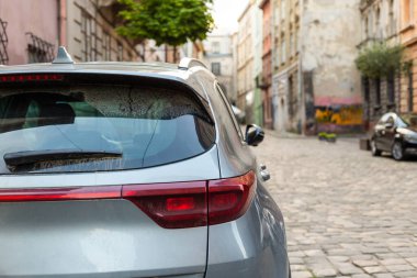 Yazın güneşli bir günde, arka pencereye park etmiş gri bir araba. Çıkartma veya çıkartma için modelleme