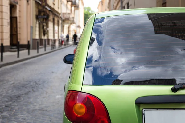 Rückscheibe eines grünen Autos, das an einem sonnigen Sommertag auf der Straße geparkt war, Rückansicht. Mock-up für Aufkleber oder Abziehbilder — Stockfoto