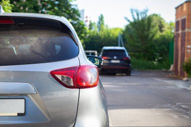 Yazın güneşli bir günde, arka pencereye park etmiş gri bir araba. Çıkartma veya çıkartma için modelleme