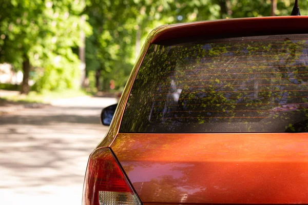 Janela traseira do carro vermelho estacionado na rua no verão dia ensolarado, vista traseira. Mock-up para adesivo ou decalques — Fotografia de Stock