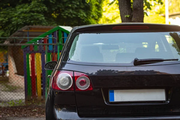 Janela traseira do carro preto estacionado na rua no verão dia ensolarado, vista traseira. Mock-up para adesivo ou decalques — Fotografia de Stock