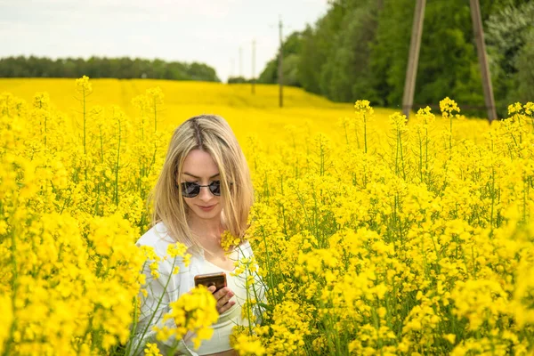 Girl Phone Her Hands Stands Middle Rapeseed Field — Stock Photo, Image