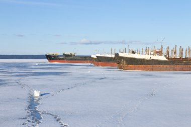 Kış zamanında Onega Gölü limanda eski donmuş kargo gemileri