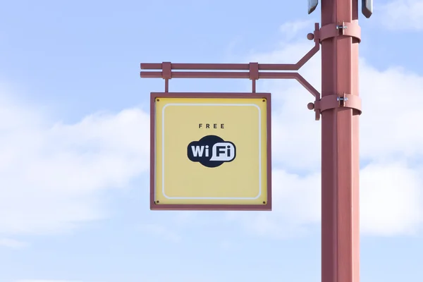 Free WiFi - wireless internet sign on the pole on blue sky background — Stock Photo, Image