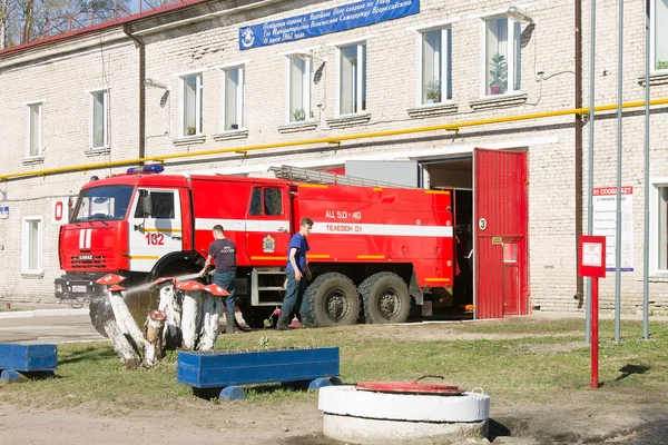 LODEYNOJE POLE, RUSIA - 2 DE MAYO DE 2016: Bomberos no identificados lavando su camión de bomberos junto al garaje —  Fotos de Stock