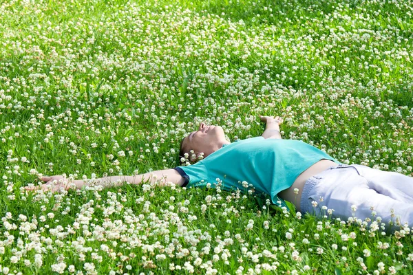 Silah yeşil yaz çayır üzerinde uzanmış yatan pozitif adam