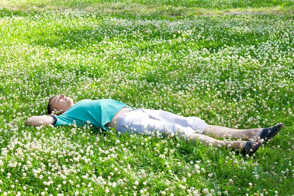 stock image Positive man lying on a green summer meadow