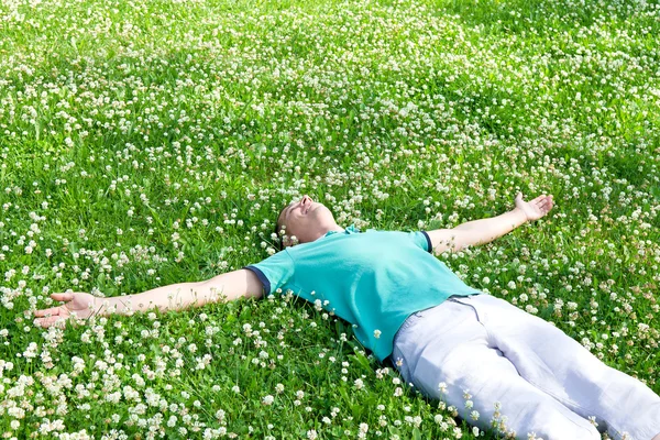 Mutlu adam silah yeşil yaz çayır üzerinde uzanmış yatan 