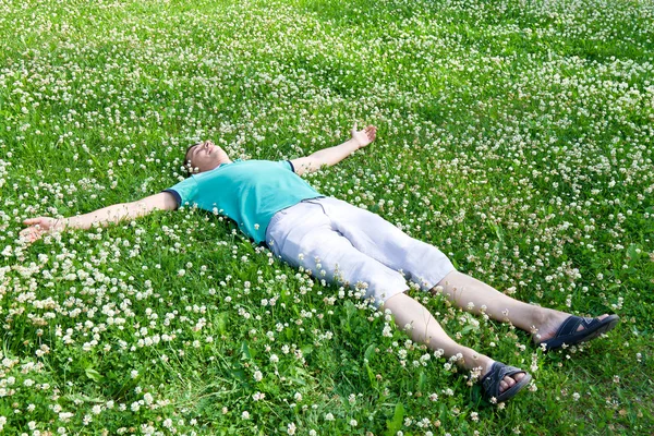 Happy man lying arms outstretched on a green meadow — Stock Photo, Image