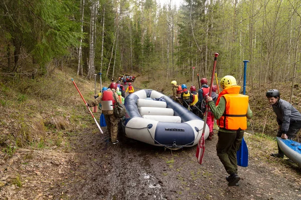 Bir grup turist, lastik botu kıyıdan Rusya ve Karelia nehri boyunca alçalma noktasına taşıyor.