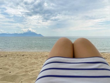 Athos Dağı manzarası ve kız bacakları ve çizgili elbisesi.