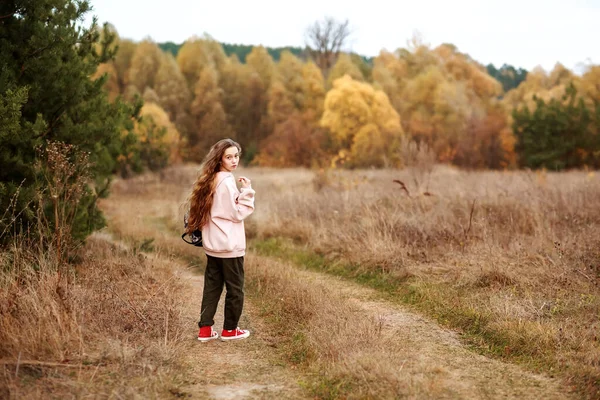 Portrait of a teenage girl in casual clothes on the background of an autumn landscape. — Stock Photo, Image