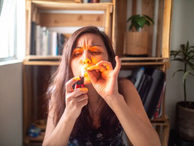 Siyah Elbiseli Genç Çekici İspanyol Kadın Pencerenin yanındaki sigarayı yakıyor