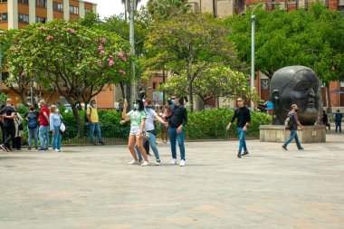Medellin, Antioquia, Kolombiya - 6 Ocak 2021 Plaza Botero 'nun ortasında Dans Eden Maskeli Gençler