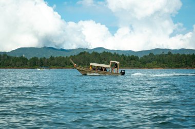 Guatape, Antioquia, Kolombiya - 3 Nisan 2021: Turistlerle El Peol yakınlarındaki sularda gezinen bir elektrikli tekne