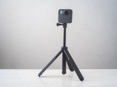 Beyaz ve Gri bir yüzeye karşı aksesuarları olan bir Mini Üçayaklı Kamera 360