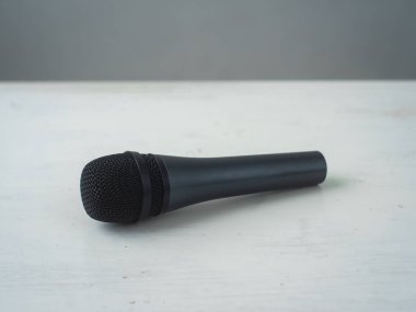 Mikrofon beyaz ve gri bir yüzeye karşıdır