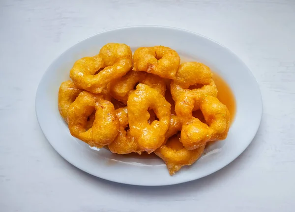 Picarones, Peru Tatlısı Kabak ve Tatlı Patatesten yapılır ve Panela 'dan yapılan şurupla birlikte beyaz masa üzerinde servis edilir.