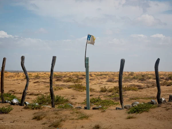 Some Logs Built as a Fence with a Broken Flag in a Desert Near a Bay in Bahia Honda, La Guajira, Colombia