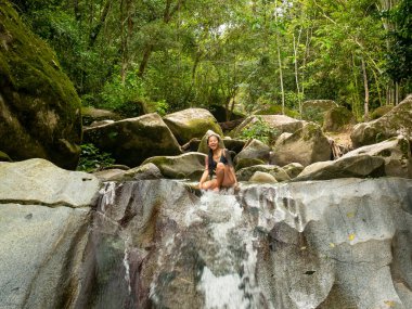 Şelalenin kenarındaki Asyalı kadın Minca, Kolombiya 'ya atlamak üzere.
