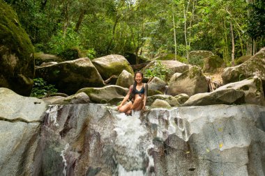 Şelalenin kenarındaki Asyalı kadın Minca, Kolombiya 'ya atlamak üzere.