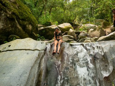 Şelalenin kenarındaki Asyalı kadın Minca, Kolombiya 'ya atlamak üzere.