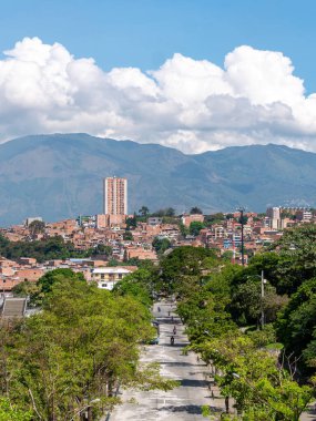 Medellin şehrinin manzarası, binalar, dağlarla çevrili ağaçlar güneşli bir günde