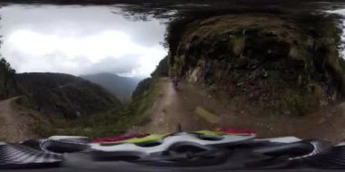 Los Yungas, La Paz, Bolivya - 14 Eylül 2018: 360 Degree View of a Young Men using a Mimet and Riding a Bicycle on a Dirty Road on the Famous 