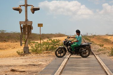 Uribia, La Guajira, Kolombiya - 28 Mayıs 2021: Çöldeki Demiryolu Raylarında Başlıksız Motorsiklet Süren Yerel Gençlik