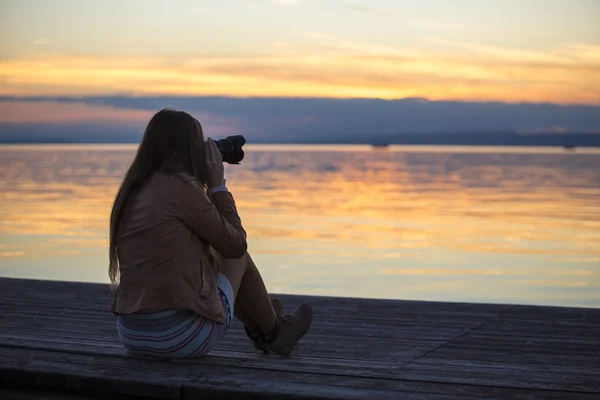 Fille photographiant coucher de soleil au lac en automne — Photo