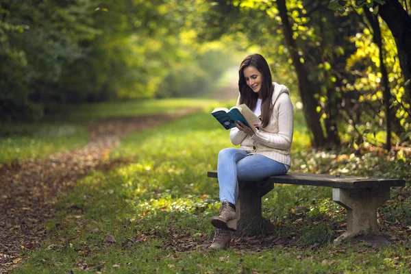 Красива дівчина сидить на лавці парку — стокове фото