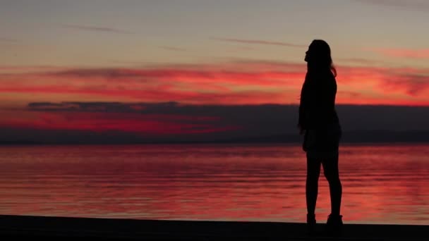 Chica está caminando al atardecer en el lago — Vídeos de Stock