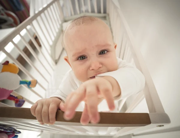 Small abandoned baby in the crib crying — Stock Photo, Image