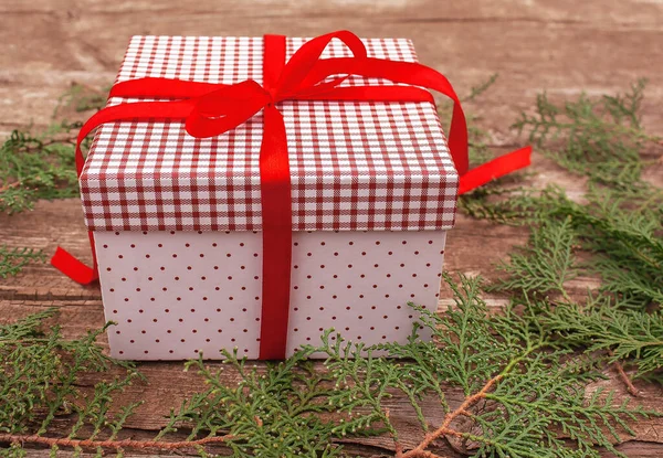 Gift Box Red Ribbon Table Surrounded Coniferous Branches — Stock Photo, Image