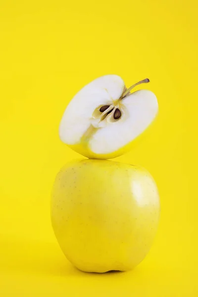 Half Apple Stands Whole Yellow Apple Yellow Background — Stock Photo, Image