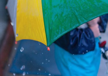 Şemsiyeye yağmur damlaları düşüyor. Doğada yağmurda yürümek