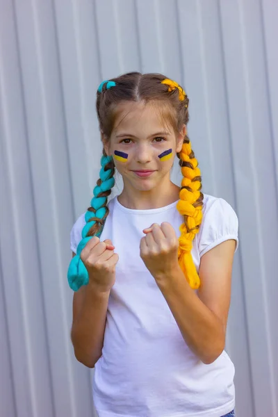 Mavi ve sarı saçlı neşeli Ukraynalı kız gücünü gösteriyor. Spor ve fan destek konsepti. Ukrayna 'nın vatanseverliği ve bağımsızlığı.