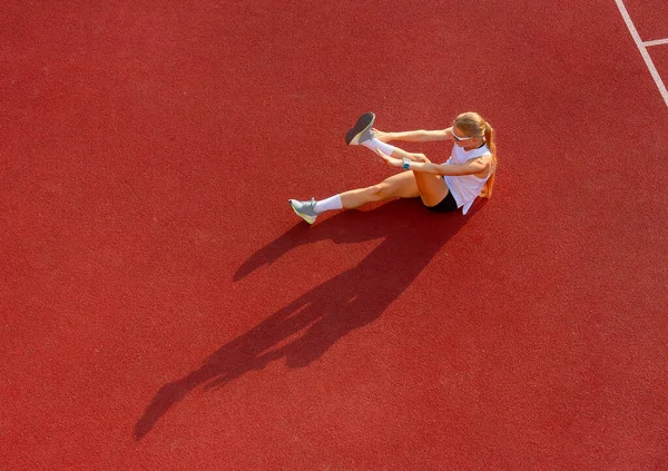 Stadyumdaki genç bayan spor egzersizleri yapıyor. Spor eğitimi, fitness, sağlıklı yaşam tarzı konsepti.