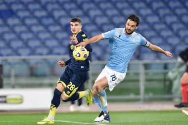 ROME, ITALY - 21 Ocak 2021 'de SS Lazio' dan Marco Parolo (R), SS Lazio ile Parma Stadio Olimpico arasında oynanan 18. TIM Kupası maçında Parmalı Valentin Mihai Mihaila (L) 'a karşı eylemde.