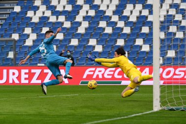 Giulio Maggiore (Spezia) ve Andrea Consigli (Sassuolo), İtalya 'nın Reggio Emilia kentindeki MAPEI Stadyumu' nda oynanan Amerikan Sassuolo-AC Spezia maçında topa ulaşmaya çalışırlar.