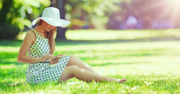 Женщина читает книгу в парке — стоковое видео