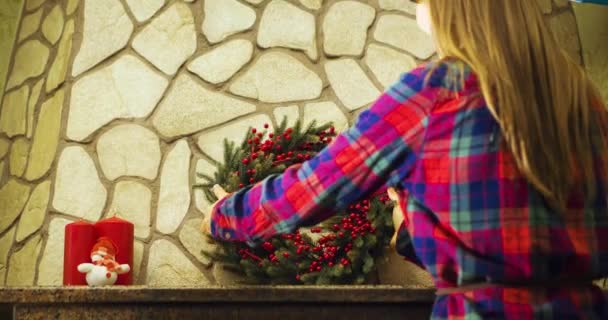 クリスマスの花輪と暖炉を飾る女性 — ストック動画