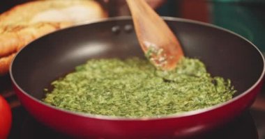 Woman preparing food on frying pan 
