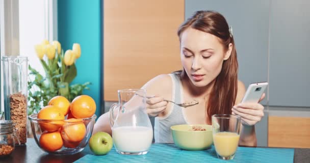 Žena s smartphone jíst zdravé snídaně — Stock video