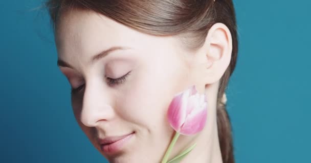 Beautiful woman with pink tulip — Stock Video