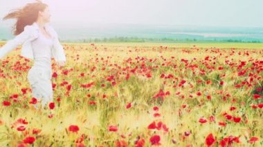 Woman running through poppies field