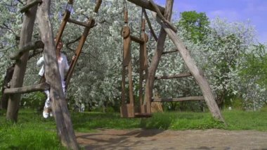 Young cheerful woman on swings