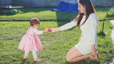 Mother giving flower to baby daughter