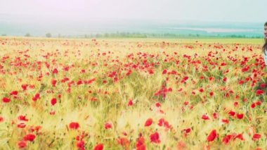 Woman running through poppies field